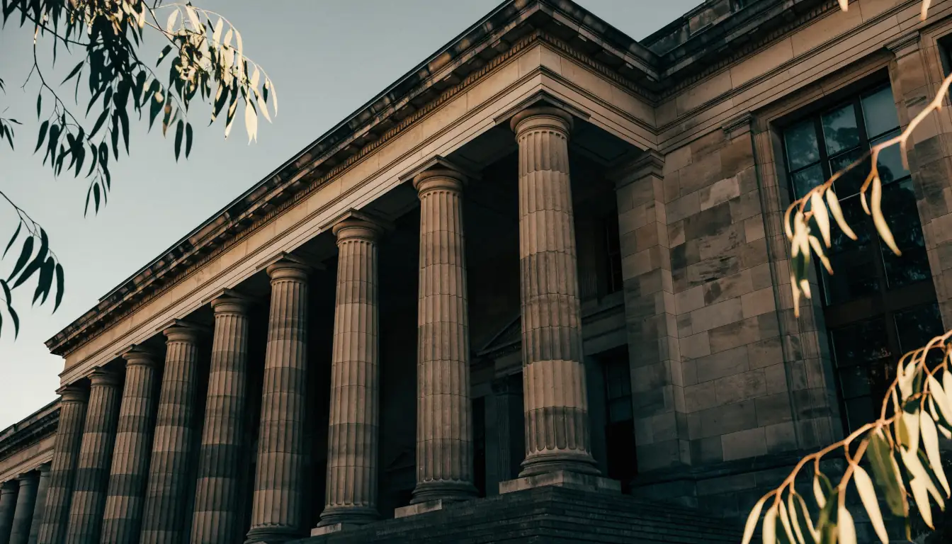 Sandstone civic building with neoclassical columns in warm Australian afternoon light.